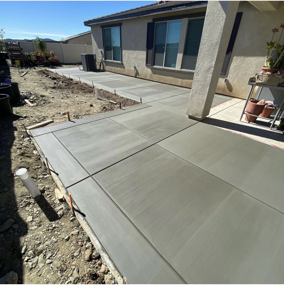 Freshly finished concrete patio and side walkway alongside a residential home