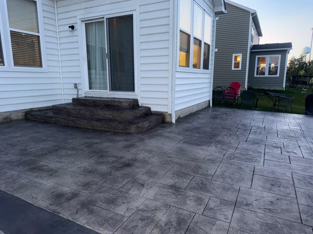 Finished stamped concrete outdoor living patio with tiered landing steps