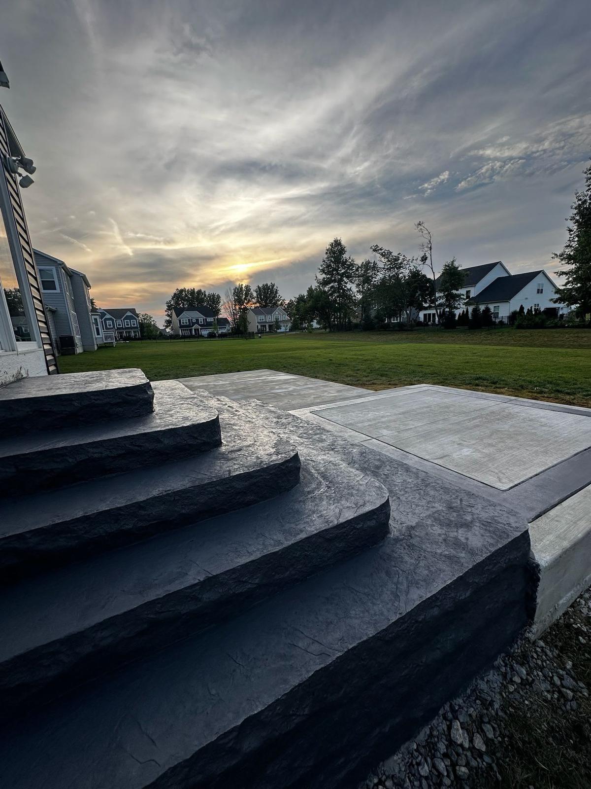 Deep charcoal stamped curved steps with custom stone texture