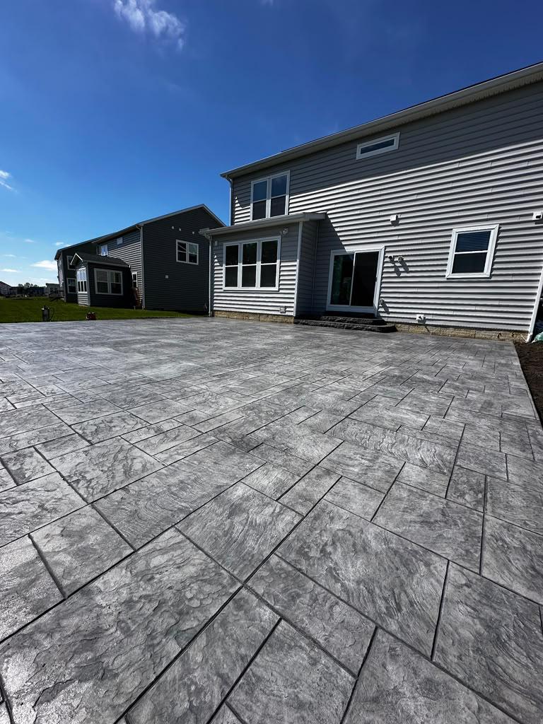 Large residential stamped slate patio slab under clear sky