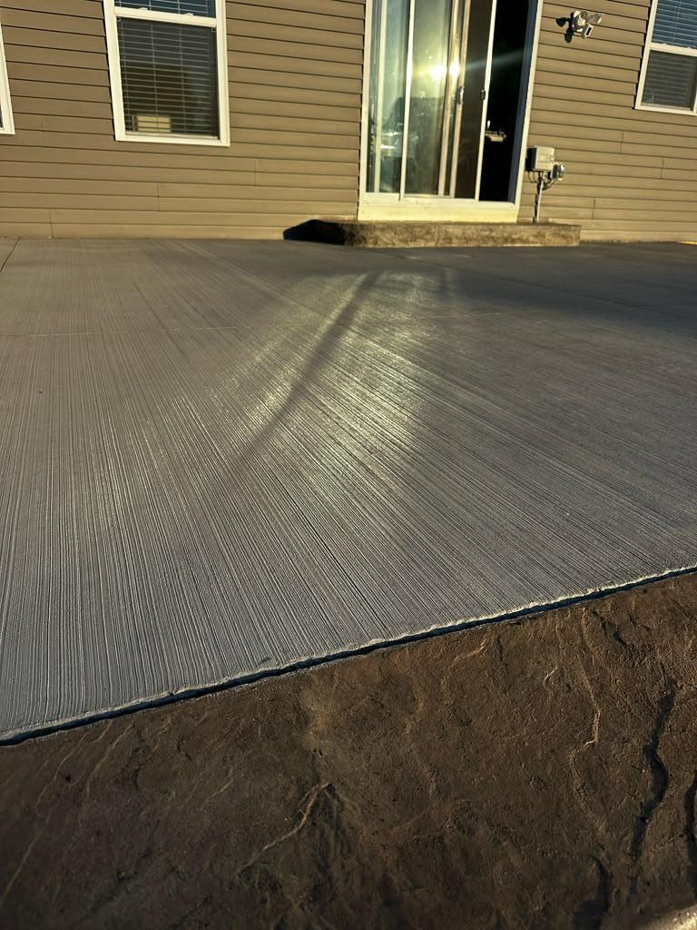 High-traction broom finish walkway surface meeting stamped stone border
