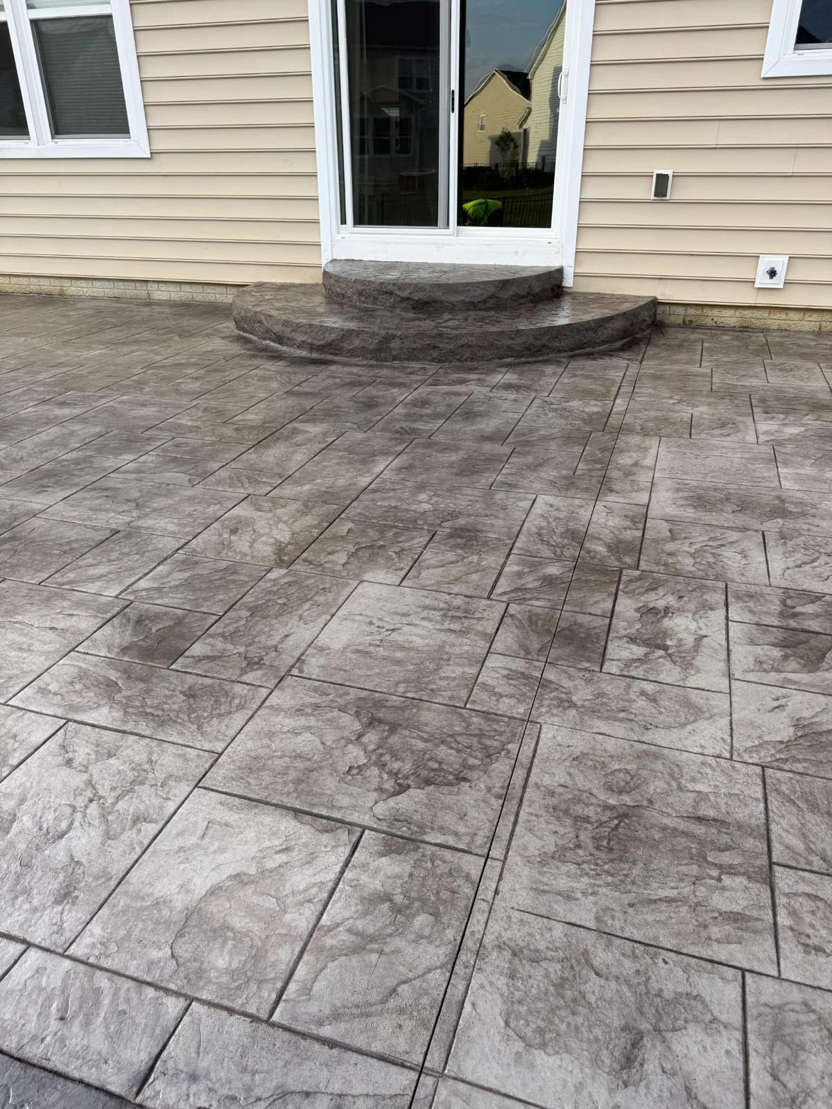 Charcoal ashlar slate stamped patio with rounded landing